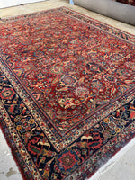 Antique Persian Mahal rug with warm red field and floral patterns.