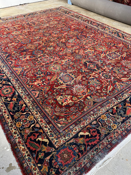 Antique Persian Mahal rug with warm red field and floral patterns.