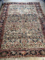 Full view of an antique 1880s Persian Mahal rug with worn ivory field and blue botanical motifs.