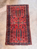 Small Persian entryway rug displaying geometric abstraction and organic tree of life patterns.
