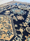 Close up of navy blue ground on antique Persian Malayer rug with decorative motifs.