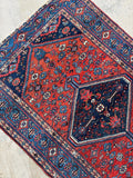 Small antique Persian rug with low pile and geometric floral design, perfect for entryway or kitchen styling.