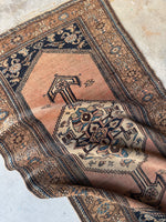 Peach ground Persian rug with sky blue and navy blue accents.