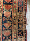 Detail of antique Persian rug border showing traditional tribal fence of security motifs.
