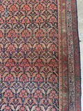 Large antique rug with navy field and beautifully balanced borders.