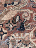 Oversized vintage rug close up showcasing natural historic wear and aged color palette.