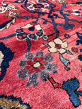 Oversized antique Persian rug featuring a sprawling botanical pattern in lavender, blue, beige, and ivory.
