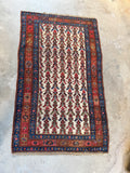 Antique Persian rug with ivory field and geometric flower design.
