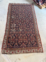 Antique Persian rug with all-over Mahi fish design on navy blue field.