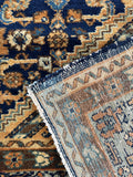 Underside detail of antique Persian rug with intact edge and minor age wear.