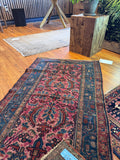 Persian village rug from the 1920s with floppy handle and saturated natural dyes.