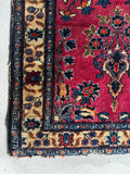 Antique Persian Sarouk rug featuring a contrasting yellow border with floral vine patterns.