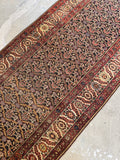 Hand knotted Persian runner, 1920s Bakhtiari antique rug with rich brick red borders, dark chocolate field, and intricate geometric floral artwork.