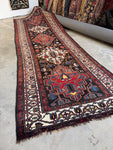 Full view of antique Persian runner with alternating warm and ivory medallions.