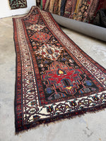 Full view of antique Persian runner with alternating warm and ivory medallions.