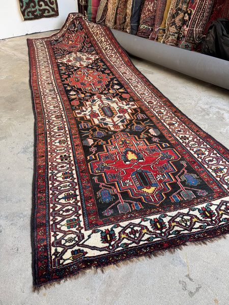 Full view of antique Persian runner with alternating warm and ivory medallions.