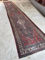 Antique Persian runner with bold tribal medallions and soulful character from wear.