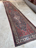 Antique Persian runner with bold tribal medallions and soulful character from wear.
