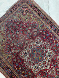 Angle view highlighting texture, pile condition, and natural vegetable dye variation on 4'x5' antique Sarouk rug.