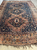Antique Shiraz rug laid out with visible character and wear.