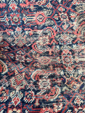 Close-up of antique Persian rug showing detailed Herati design with natural wool colors.