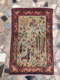 Antique Persian Tabriz pictorial rug laid flat, featuring a sage green field with a detailed hunting scene.