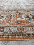 Close up view of large Persian Tabriz rug with a powder blue ground and ornate decorative detailing.