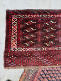 Persian Yomut small tribal rug highlighting the plush wool pile, deep red field, and intact woven edges.