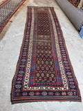 Hand knotted antique Persian village runner with geometric pattern and low wool pile.