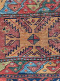 Close up of colorful tribal Bidjar area rug with hooked medallions and serrated floral motifs.
