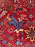 An antique vegetable dyed Persian Heriz rug in deep red and blue.