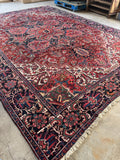 Large 10x14 antique Persian Heriz rug. Hand knotted 1920s rug with bold geometric tribal design, vivid vegetable dyes, ivory corner spandrels, and full wool pile.