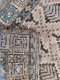 Worn antique accent rug underside view showcasing authentic late 19th-century patina and textured weave.