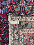 Underside view of handwoven 1930s Persian runner with floral pattern and aged character.