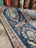 Vintage Persian hallway runner displaying rich vegetable-dyed navy wool and soft pink accents.