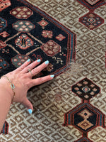 Handwoven Persian runner showing scattered wear.