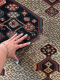 Handwoven Persian runner showing scattered wear.
