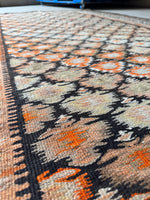 Antique tribal runner with vibrant tangerine accents.