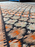Antique tribal runner with vibrant tangerine accents.