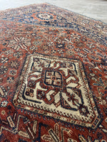 Aged Shiraz rug with oxidized brick-rust, dusty blue, and terracotta hues.
