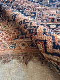 Antique Persian Shiraz rug showing its floppy handle and movement.