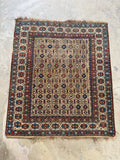 Full view of vintage nomadic Caucasian rug with linear rows of geometric tribal motifs.