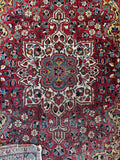 Close up view of small 4x5 vintage Persian accent with a central medallion.