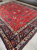 Antique Persian Tabriz rug, 9’3 x 12’6, with deep red field and navy border.