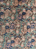 Close up of 1920s Tabriz rug 10’4 x 14’ earthy tones with teal accents.