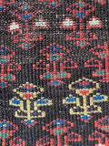 Close up of vintage Persian hallway runner with handwoven character and width variation.