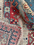 Authentic Caucasian tribal runner rug close-up revealing fine hand-knotted wool construction and soft patina.