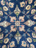 Close up of antique navy ground Sparta rug with low pile and intricate floral artwork throughout the field.