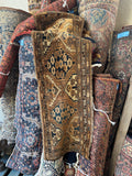 Antique Turkoman runner rug featuring hand-knotted geometric tribal patterns in rich earthy brown and tan wool.