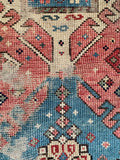 Antique tribal area rug displayed flat to showcase low pile wear and natural wool color variations.